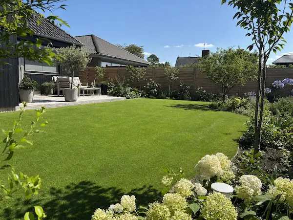 Velplejet have med grøn græsplæne og terrasse